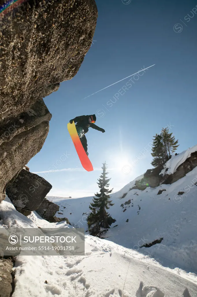 Athlete snowboarder is jumping with snowboard