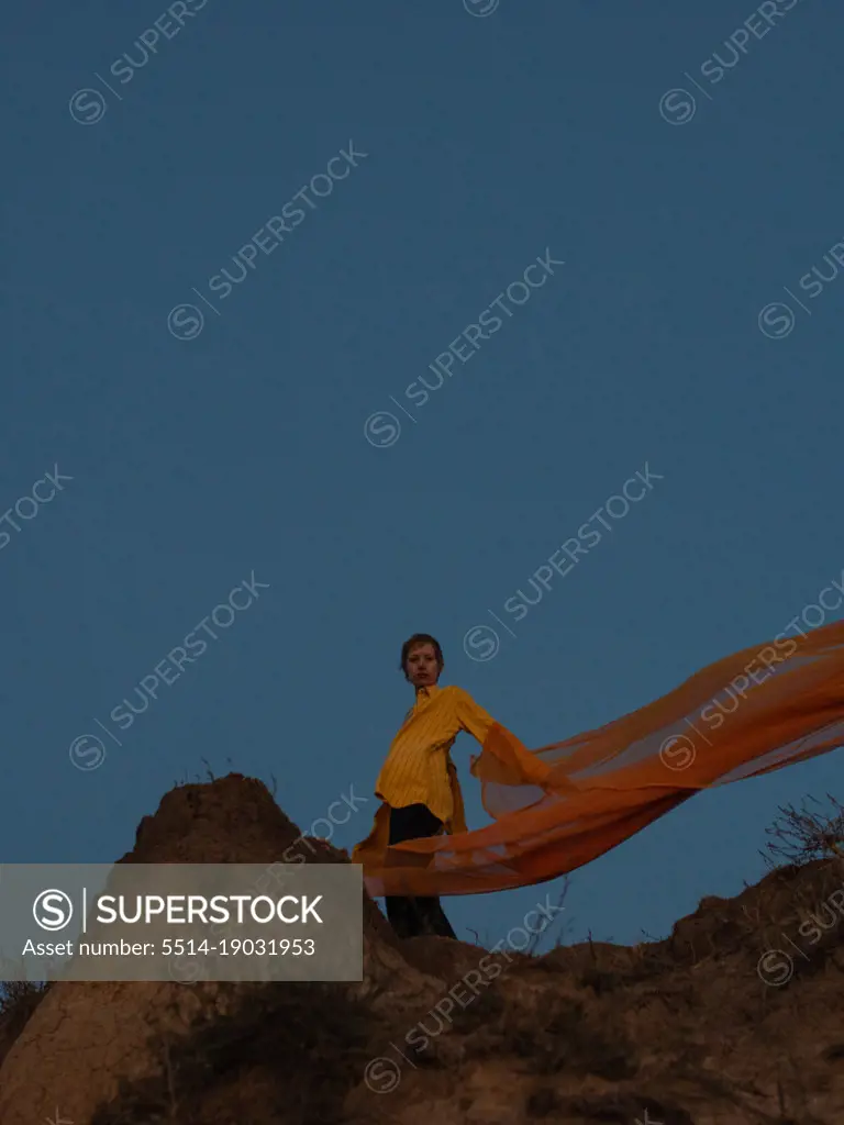woman with orange cloth in desert with blue sky