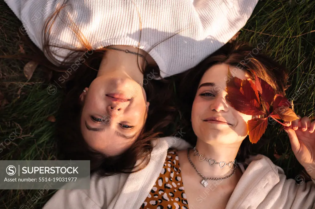 Overhead view of lesbian couple lying on grass during autumn
