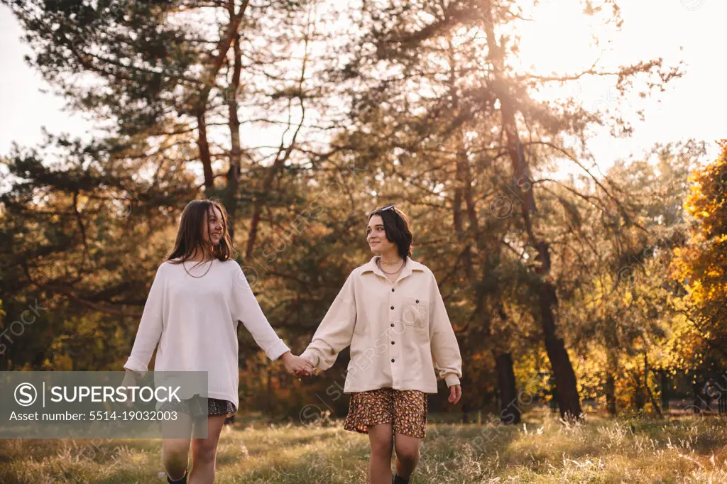 Happy lesbian couple holding hands while walking in park