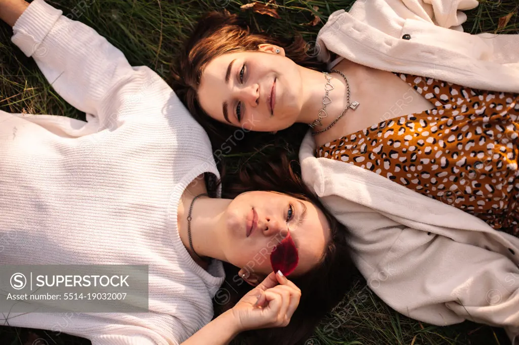 Overhead view of two young women lying on grass