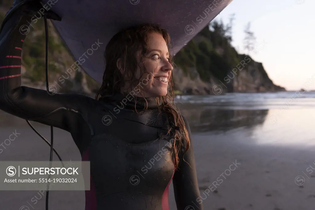 Woman carrying surfboard on head at Short Sands, Oregon