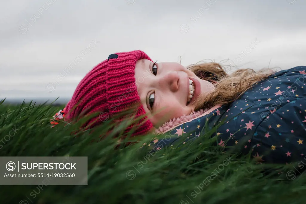 girl laying in the grass smiling relaxing in the sun