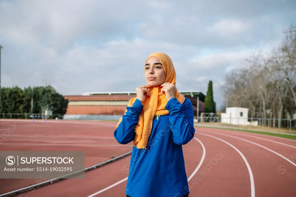 Arab woman adjusting hijab during running training