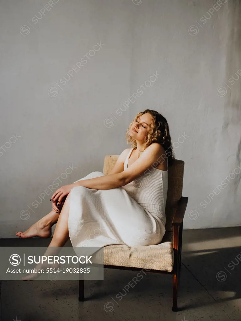 woman in white dress in armchair
