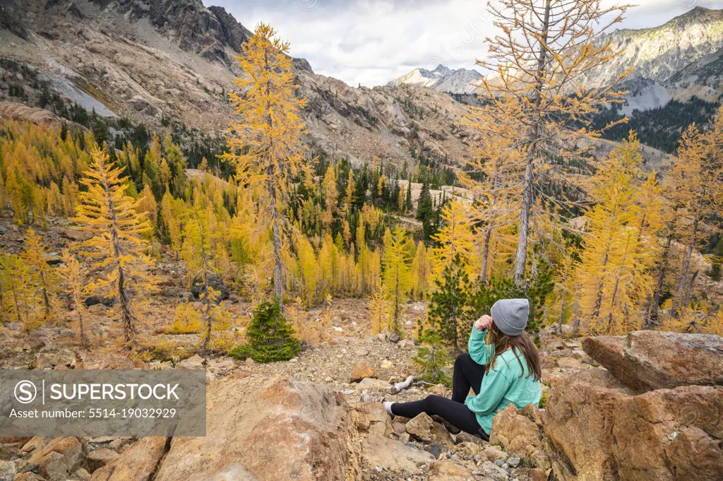 Fit female posing in a forest of alpine larches in the fall