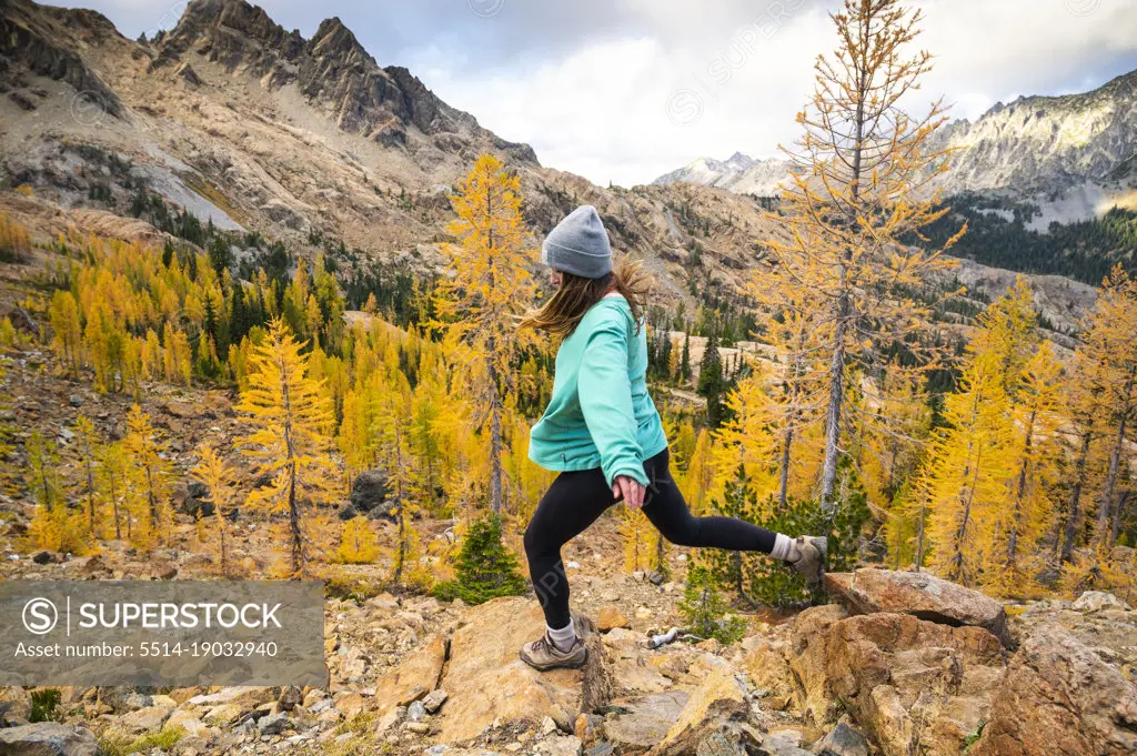 Female hiking in a basin of larches in the alpine lakes wilderness