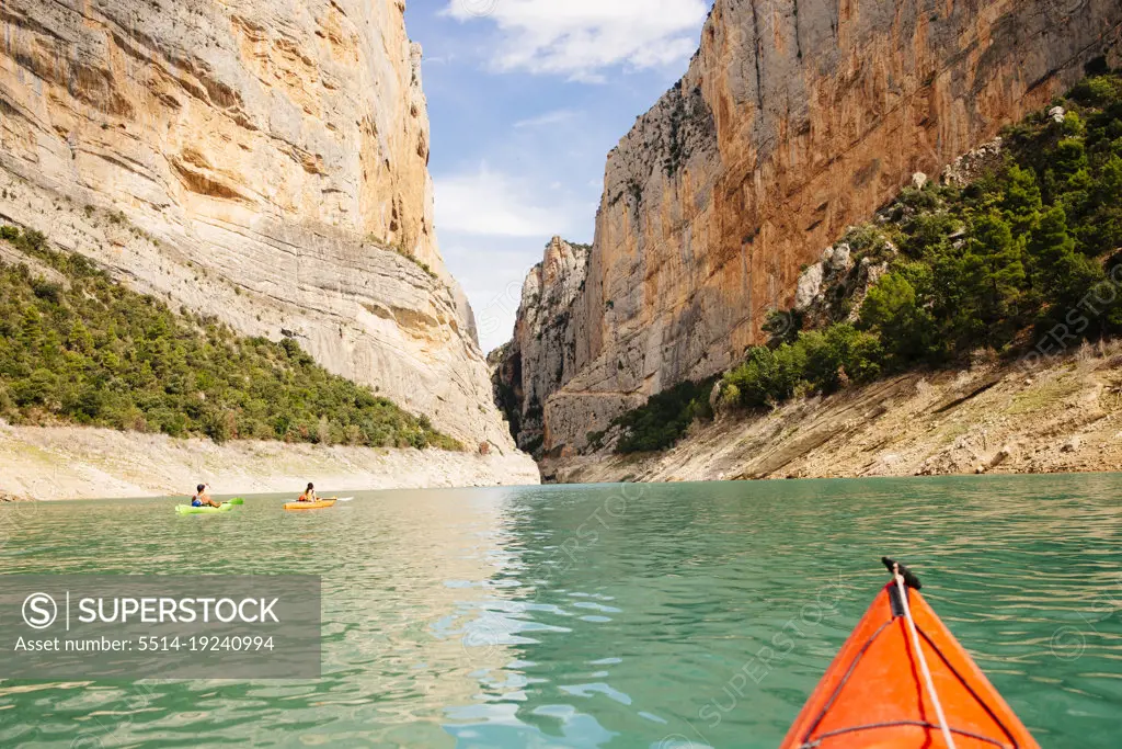 View of a canyon with a group of  kayakers navigating it.