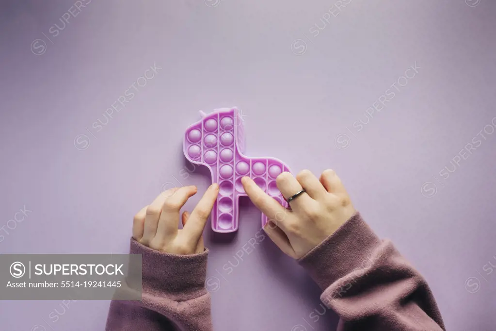 Overhead view of girl playing with a purple fidget toy