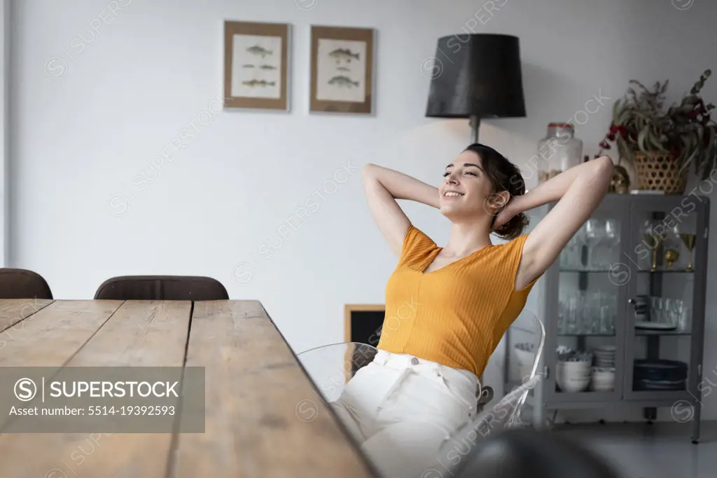 Woman sitting at dining table at home relaxing