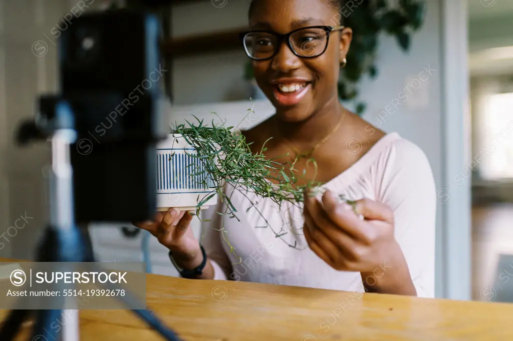 Content creator recording herself with her phone talking about plants