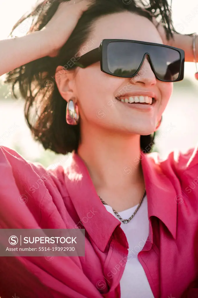 Stylish fashion woman dressed in sunglasses outdoor in the park