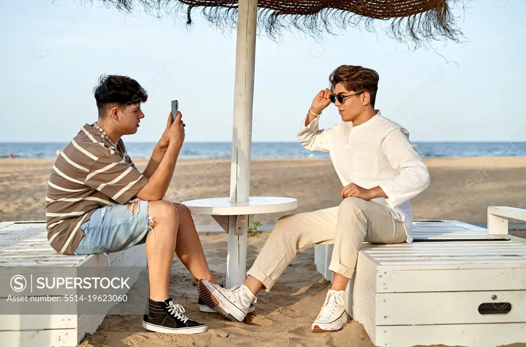 gay couple taking photos on the beach