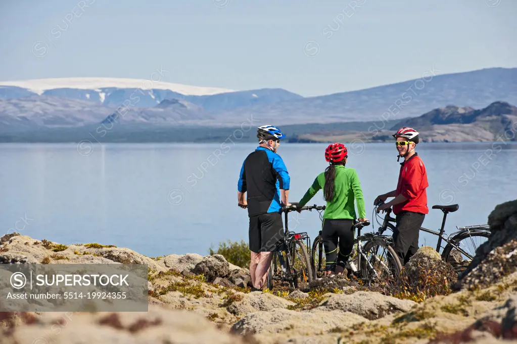 three friends cycling around Thinvallavatn lake in Iceland