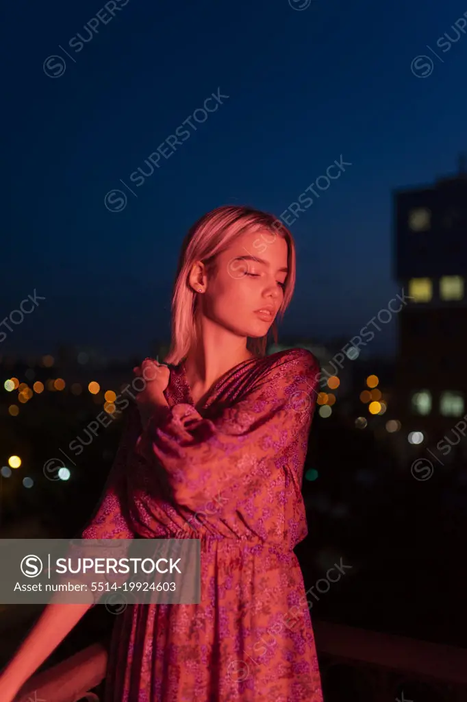 Woman in a dress on the background of the night city