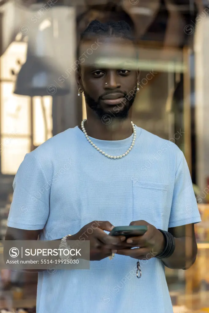 African sending a message from his smartphone