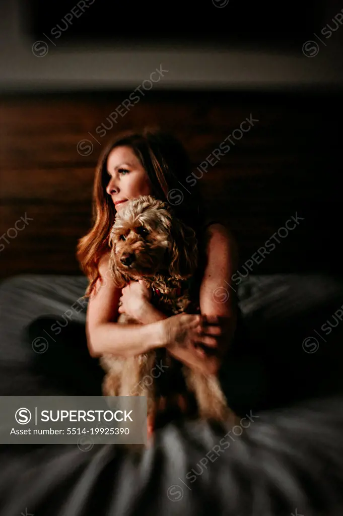 woman hugging her golden doodle puppy