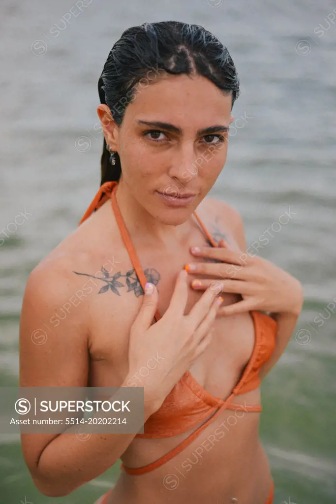 beauty girl with tattoos on the neck enjoying the beach
