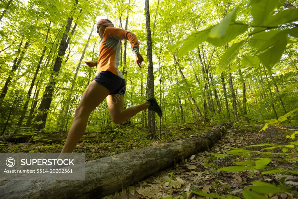 woman running in a sunny spring green forest