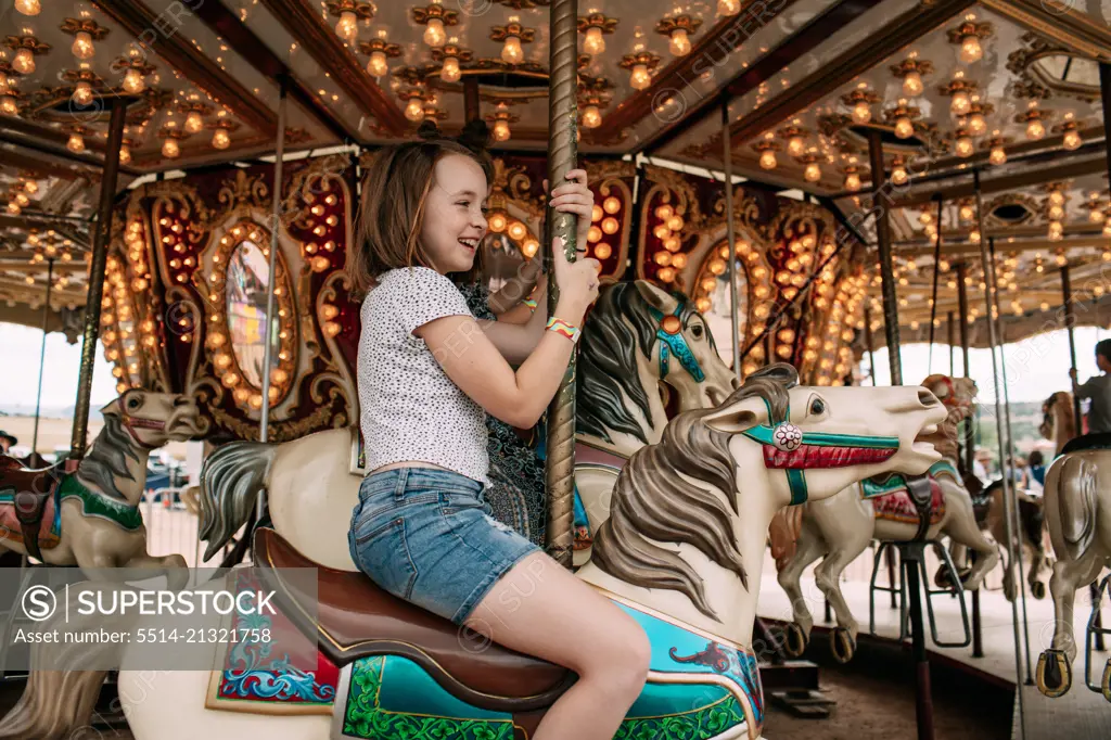 Young girl riding a carousel outside