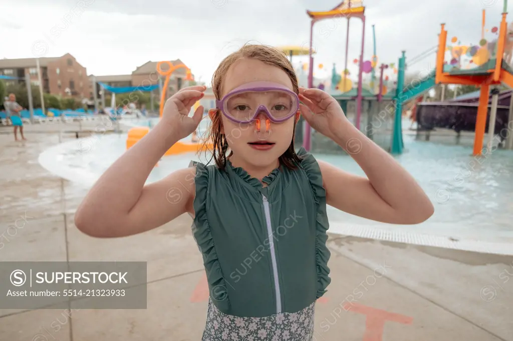 Young girl with goggles and nose plug at water park