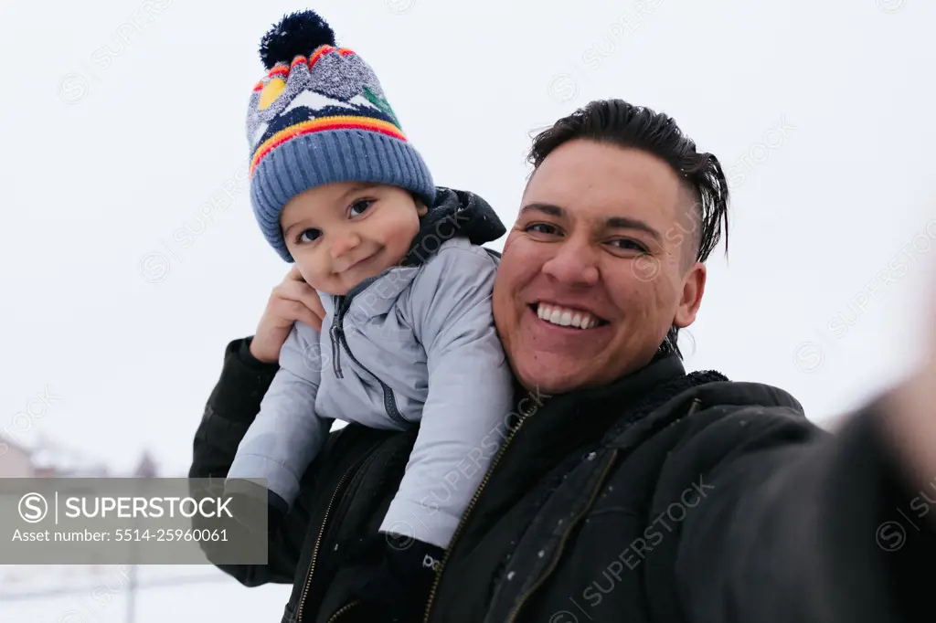 Native American dad and son taking selfie together outside in th