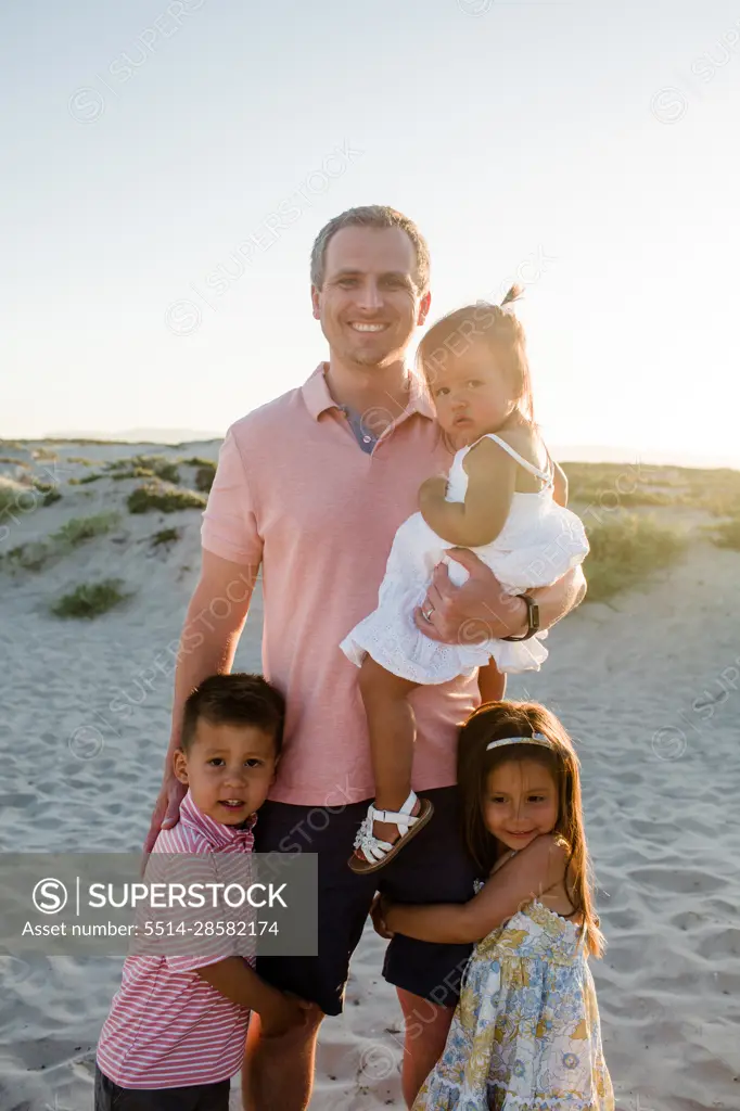 Late Thirties Dad Posing on Beach with Three Kids in San Diego