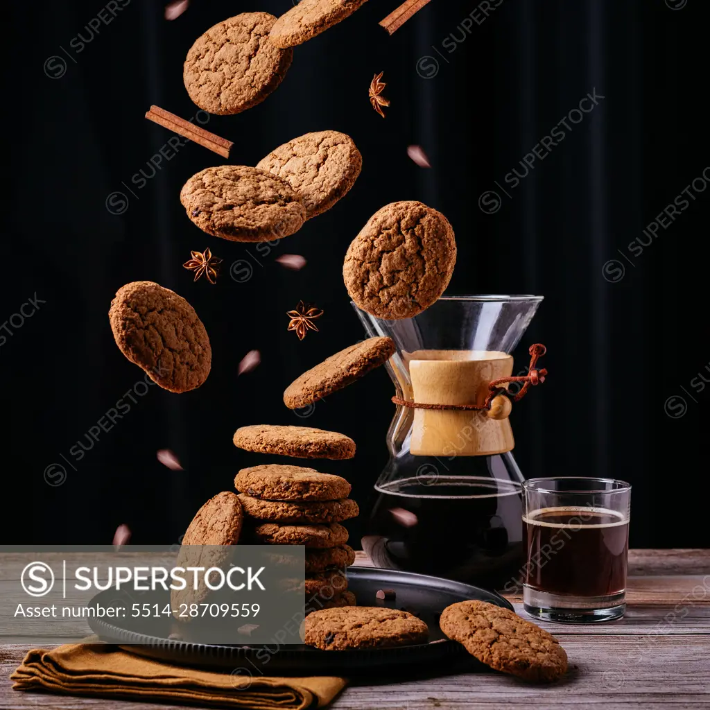 Levitating oatmeal cookies, coffee, black background