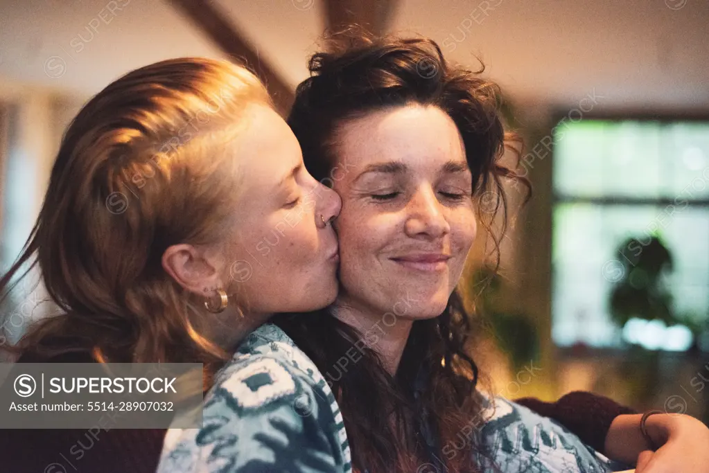 blissful love moment between two queer women cuddling at home
