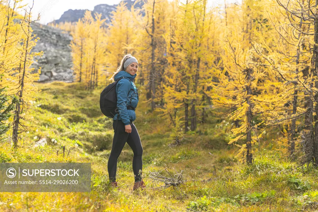 Hiker Posing in Field of Golden Larches at Paradise Valley