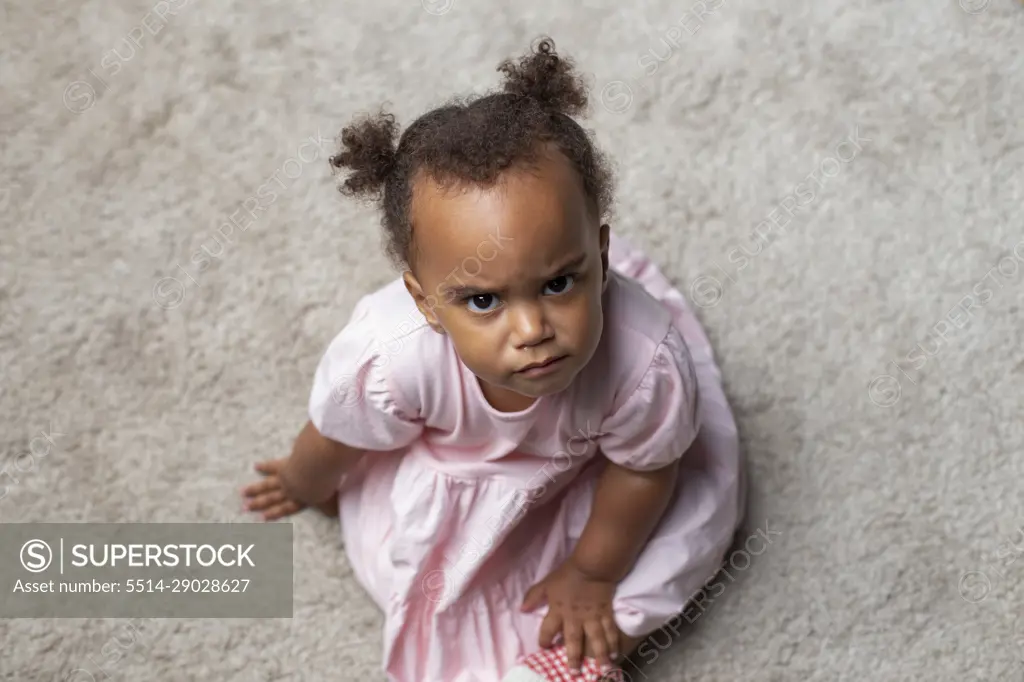 Mixed race baby girl looking up intensely