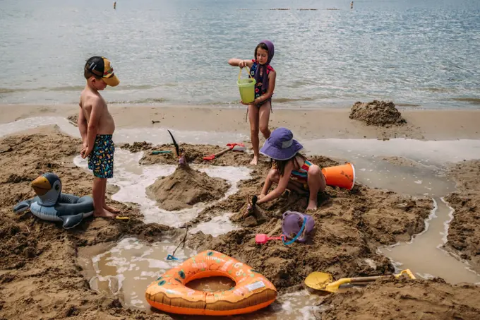 young children building sand castles on a beach in summer