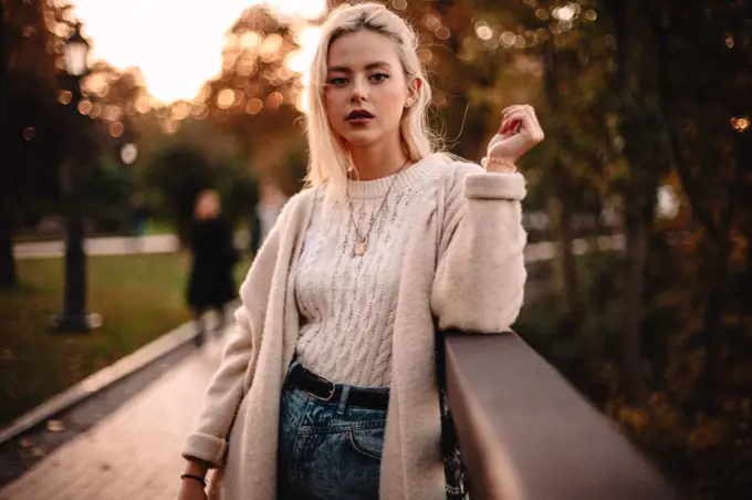 Portrait of confident young woman standing in park during autumn