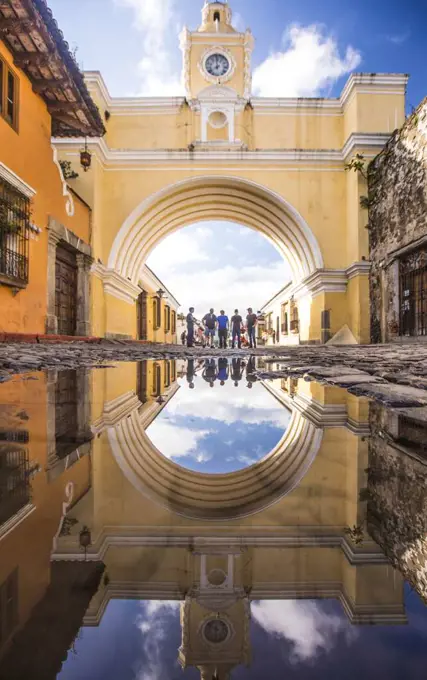 Tourists stand under the Santa Catalina arch in Antigua, Guatemala