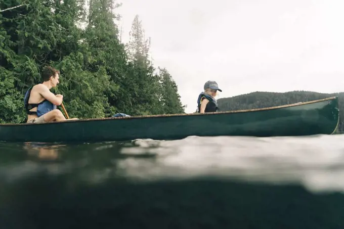 A young girl rides in a canoe with her dad on Lost Lake in Oregon.
