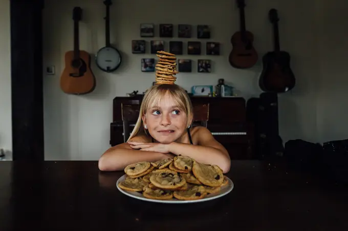 Young girl balancing cookies on her head
