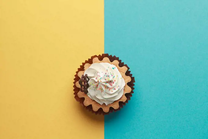 Cupcake on blue and yellow background