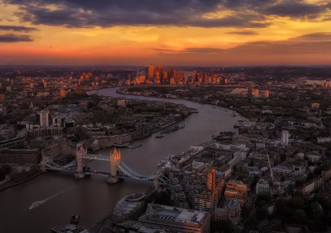 Sunset of London skyline with tower bridge and Canary wharf area in th