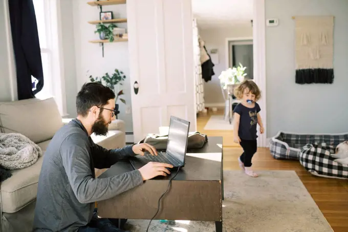 young college man and father learning with toddler daughter at home