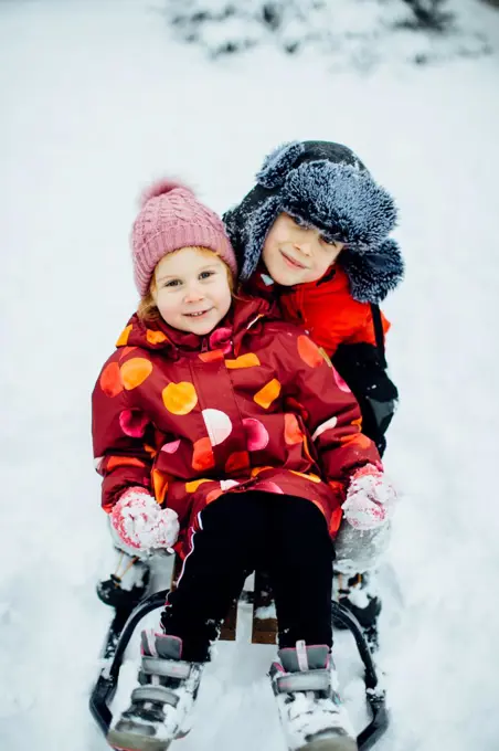 Boy and girl sitting together on the sleigh