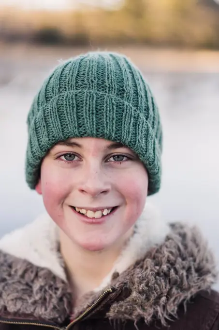 winter portrait of smiling 10 year old boy with a woolly hat