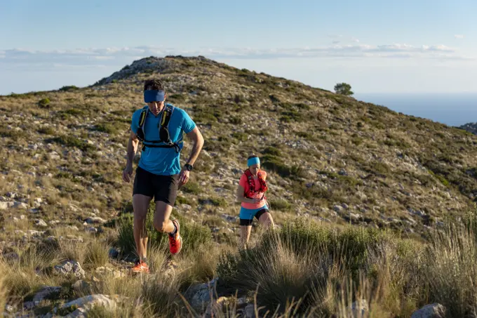 Man and woman running on mountain trail, Calpe, Costa Blanca, Alicante