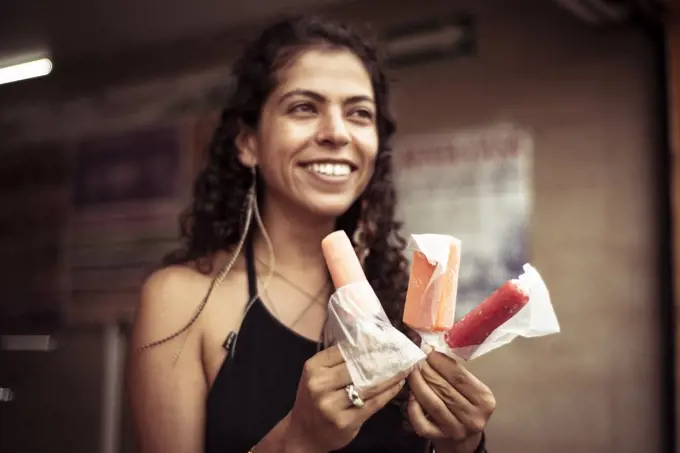 Attractive smiling young alternative Mexican woman with ice creams