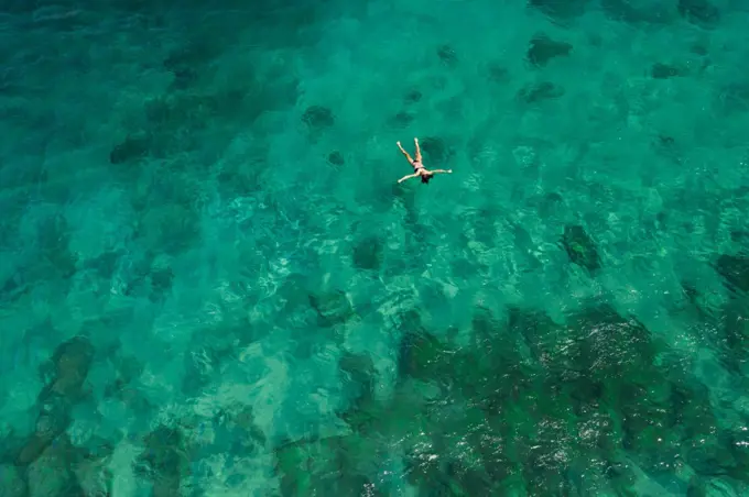 Aerial Shot of Girl Floating in Green Cove