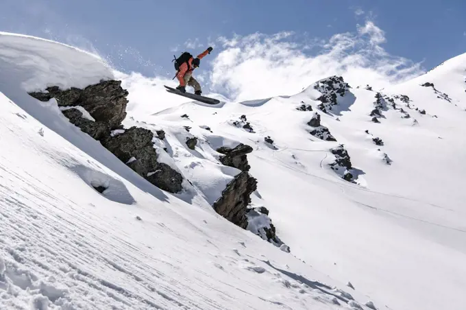 Man snowboarding on snowcapped mountain during vacation