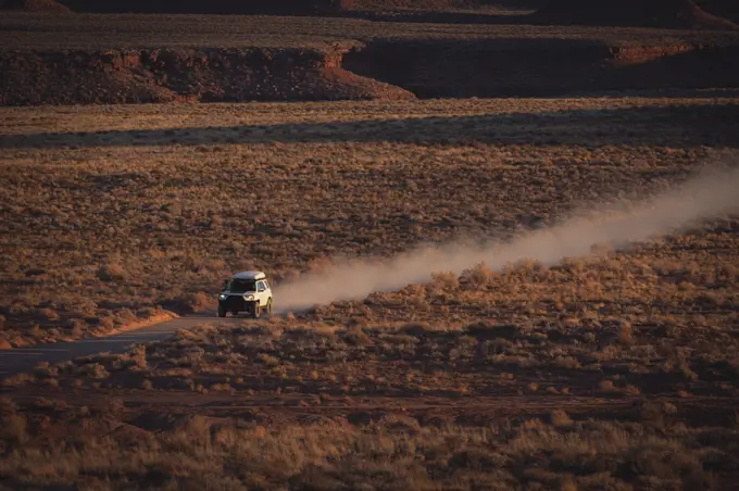 Off-road vehicle moving on dirt road at desert