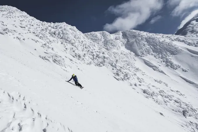Man snowboarding on slope of snowcapped mountain during vacation