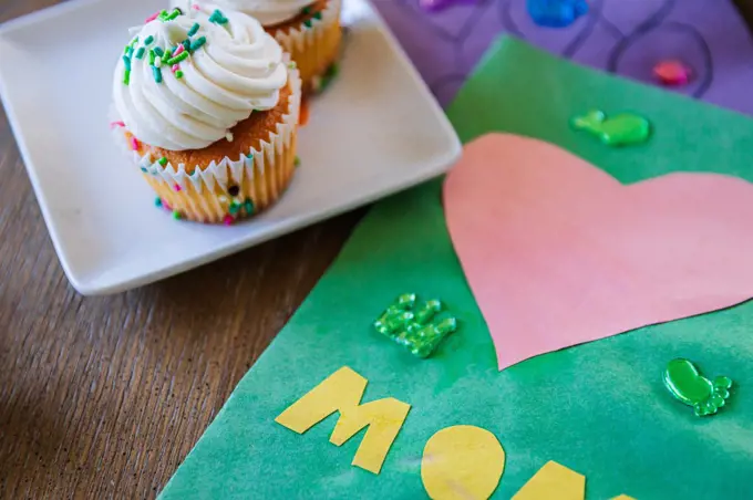 Close-up of cupcake by greeting card on table at home
