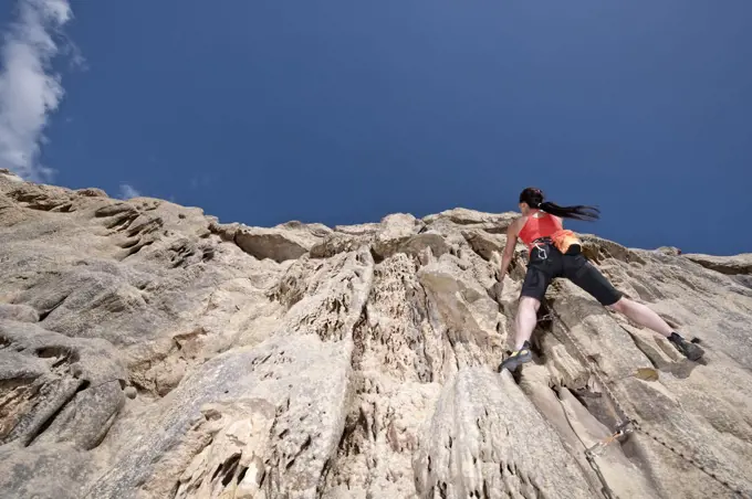Woman climbing on the limestone cliffs at Swanage / UK