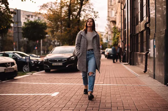 Thoughtful woman walking on street in city